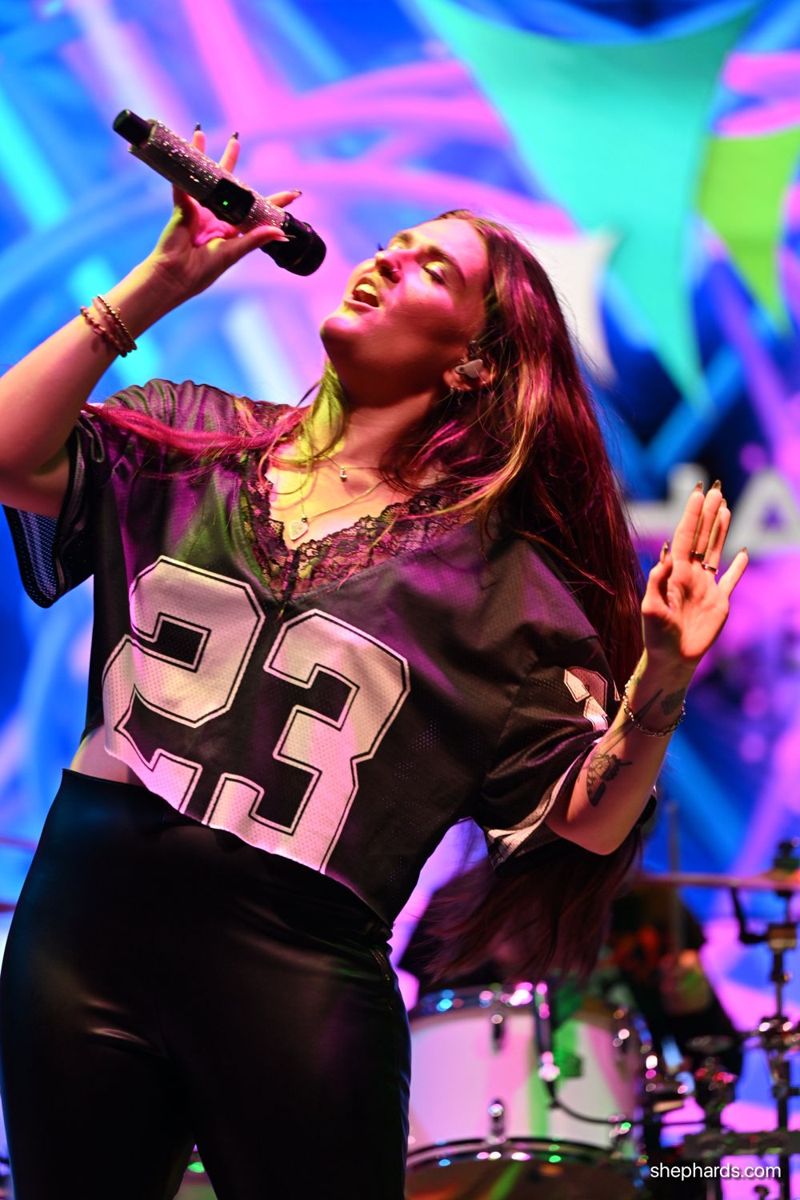Karly singing, arm raised